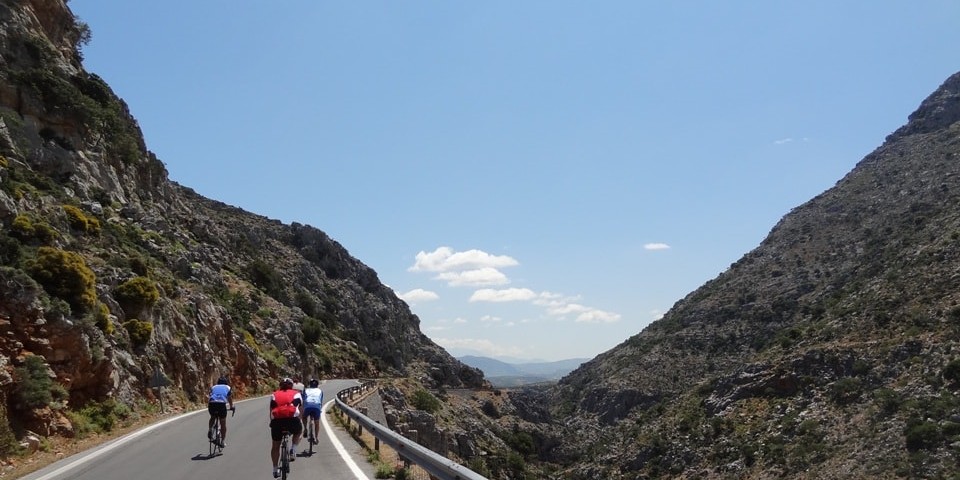 three road cyclists pass through the goniano canyon of Crete